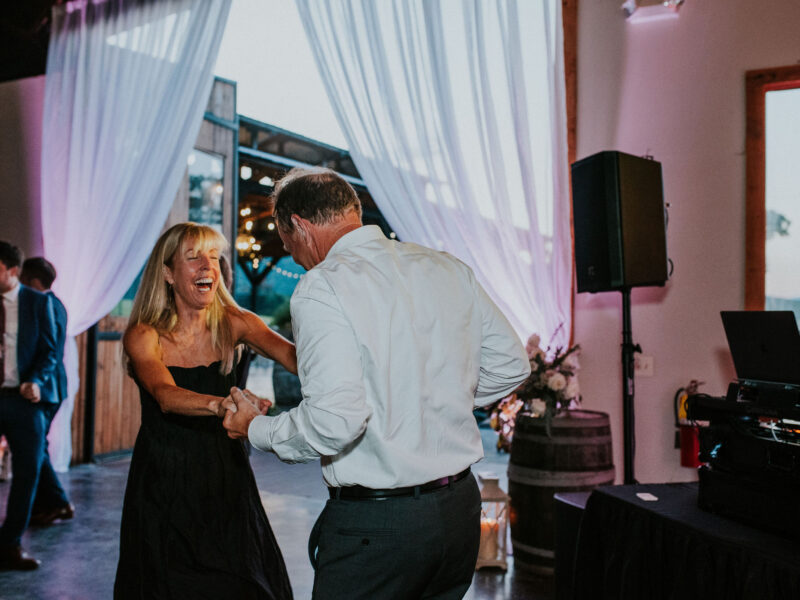 Guests dancing at White Oaks with uplights around the dance floor and on the drapes